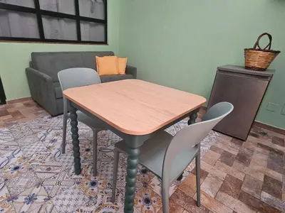 a table and chairs in a living room with a couch at Barbarò Apartments in Palermo