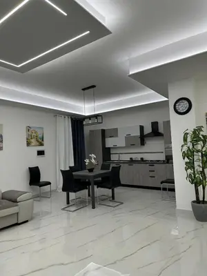 a living room with a dining table and a kitchen at Vitale House in Borgetto