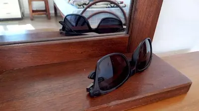 a pair of sunglasses sitting on a wooden shelf at City-Inn II with 2 comfortable single beds in Palermo
