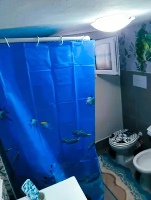 a bathroom with a blue shower with a toilet and a sink at A meravigghia casa vacanze in Bagheria