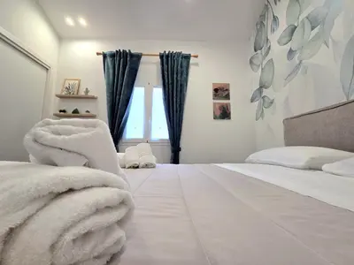 a bedroom with a bed with white sheets and a window at Angelina Rooms in Palermo