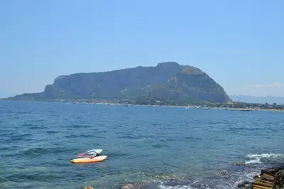an orange kayak in the water next to a mountain at La Dimora di Alice in Palermo