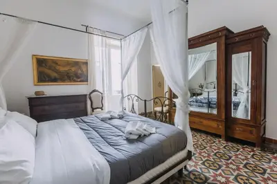 a bedroom with a canopy bed and a mirror at Real Umberto Apartments by Wonderful Italy in Palermo
