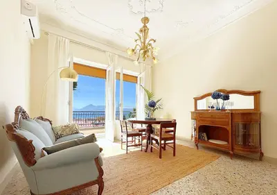 a living room with a chandelier and a table and a chair at Solemar Sicilia - Palazzo Tiglio in Porticello