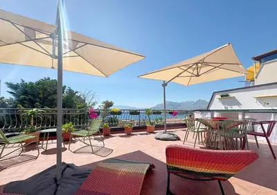 a patio with chairs and tables and umbrellas at Solemar Sicilia - Palazzo Tiglio in Porticello