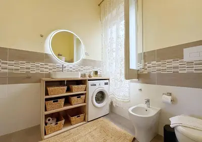 a bathroom with a washing machine and a sink at Solemar Sicilia - Palazzo Tiglio in Porticello