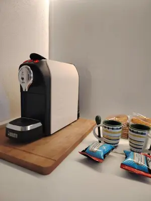 a toaster sitting on a counter next to two cups at Cappuccetto Rosso Sweet Modern Suite Palermo in Palermo