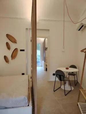 a bedroom with a bed and a table in a room at Cappuccetto Rosso Sweet Modern Suite Palermo in Palermo