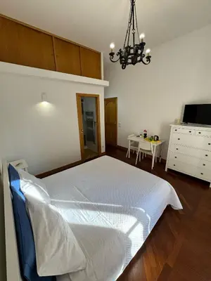 a bedroom with a white bed and a table at Dimora 51 in Palermo