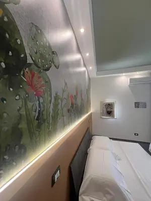a room with a bed and a painting on the wall at kumpa' sicilian apartments in Palermo