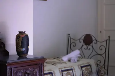 a bedroom with a bed with a vase on a table at Casa Tramontana Ospitalità Diffusa in Castronuovo di Sicilia