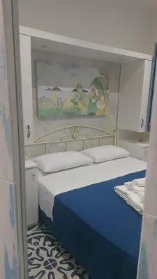 a bedroom with a blue and white bed with a painting at Benvenuti al Sud B&B in Macari