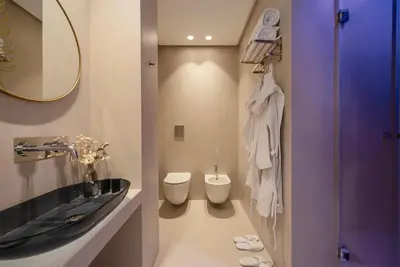 a bathroom with a sink and a toilet and a mirror at Villa Libertà in Palermo