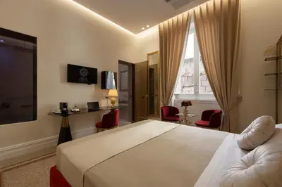 a bedroom with a large bed and red chairs at Villa Libertà in Palermo