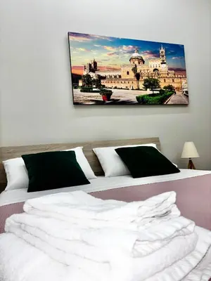 a bedroom with a bed and a painting on the wall at Santerasmo Rooms standard in Palermo