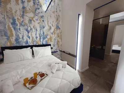 a bedroom with a white bed with two complimentary towels at Corona Suite & Rooms in Palermo