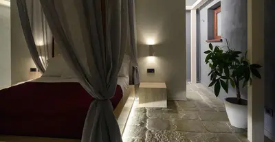 a bedroom with a bed with curtains and a potted plant at Agrirelais Principe SPA in San Giuseppe Jato
