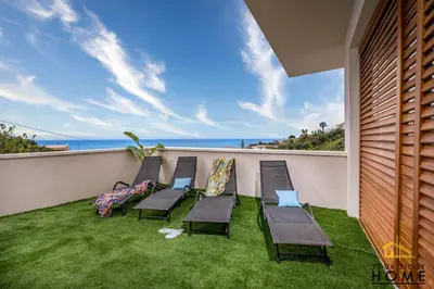 a row of chairs on a balcony with the ocean at Appartamenti in villa Ionio vista mare con piscina riscaldata e campo da bocce in Alcamo