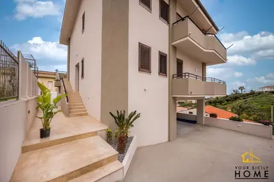 a view of a house with stairs and a balcony at Appartamenti in villa Ionio vista mare con piscina riscaldata e campo da bocce in Alcamo