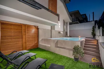 a backyard with a swimming pool and some chairs at Appartamenti in villa Ionio vista mare con piscina riscaldata e campo da bocce in Alcamo