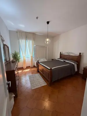 a bedroom with a bed and a table and a window at Magaggiari Beach House in Cinisi