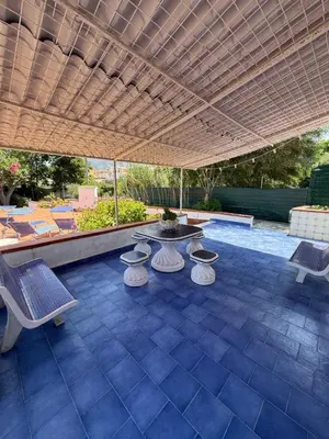a patio with chairs and a table and a fountain at Magaggiari Beach House in Cinisi