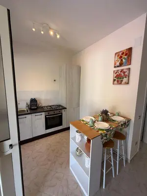 a kitchen with a counter and a table with chairs at Magaggiari Beach House in Cinisi