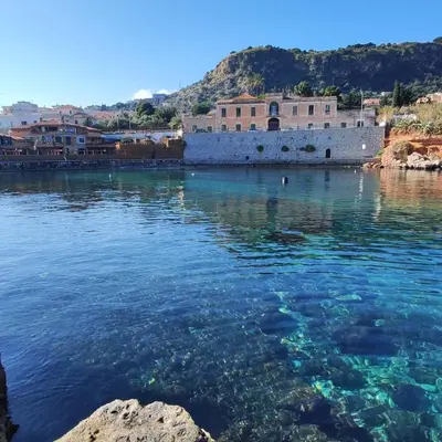 a view of the water in front of a castle at A' Terrazza in Santa Flavia