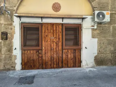 a wooden door on a building with a speaker at Casuzza Nica e Bedda-Centro storico in Palermo