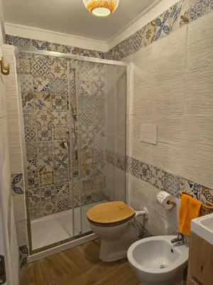 a bathroom with a shower and a toilet and a sink at Casuzza Nica e Bedda-Centro storico in Palermo