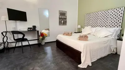 a bedroom with a bed with a desk and a chair at B&B Alla Stazione in Palermo