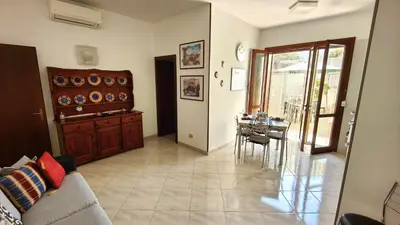 a living room with a couch and a dining room at Casa Bougainville, Mare e Relax in San Vito lo Capo