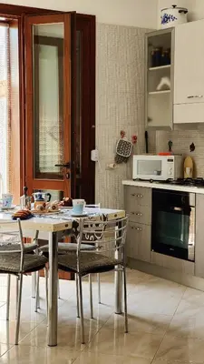 a kitchen with a table and chairs in a kitchen at Casa Bougainville, Mare e Relax in San Vito lo Capo