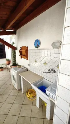 a bathroom with a sink and a washing machine at Casa Bougainville, Mare e Relax in San Vito lo Capo
