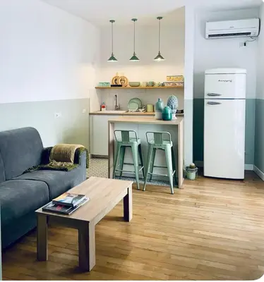 a living room with a couch and a table and a kitchen at Tarzana’ home in Palermo