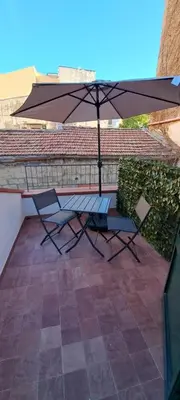 a table with an umbrella and two chairs on a patio at Expo1891 in Palermo