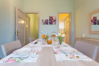 a dining room table with plates and flowers on it at Casetta Tiffany Mondello in Mondello