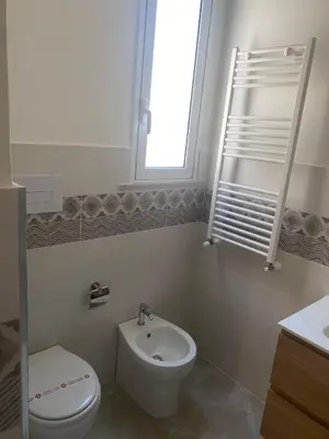 a white bathroom with a toilet and a sink at 4 Seasons in Altavilla Milicia