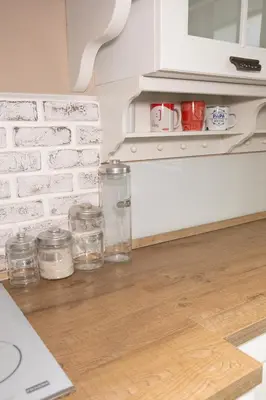 a kitchen with white brick walls and jars on the floor at Appartamento centrale 2 camere a Termini Imerese - Marconi House in Termini Imerese