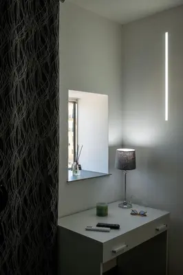 a desk with a lamp and a mirror on a wall at Santerasmo rooms Charm in Palermo