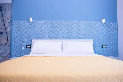 a bedroom with a bed with a blue wall at San Carlo Cuore di Palermo in Palermo