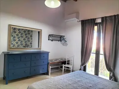 a bedroom with a blue dresser and a window at Villa Deluxe in Campofelice di Roccella