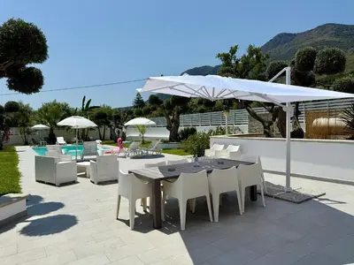 a patio with a table and chairs and an umbrella at Villa GioEle - Pool & Relax in Mandra Capreria