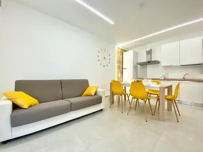 a kitchen with a dining table and yellow chairs at Appart Perla, posizione strategica in Castellammare del Golfo