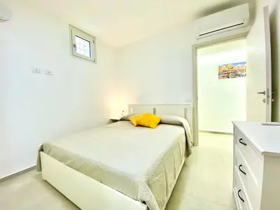 a kitchen with a dining table and yellow chairs at Appart Perla, posizione strategica in Castellammare del Golfo