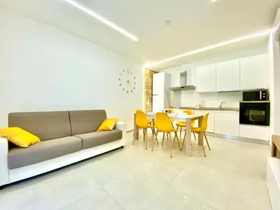 a living room with a couch and a table and chairs at Appart Perla, posizione strategica in Castellammare del Golfo
