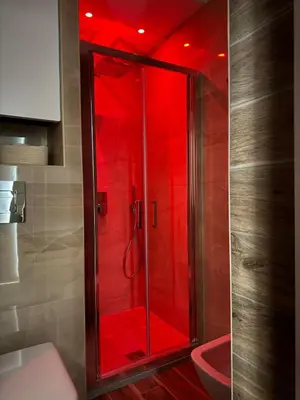 a shower with red lighting in a bathroom at Domus Vucciria in Palermo