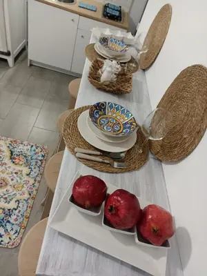 a table with plates and pomegranates on it at Naima House in Palermo