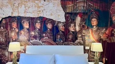 a bedroom with a wall with a mural of a painting at I Paladini ORLANDO Apartment in Palermo