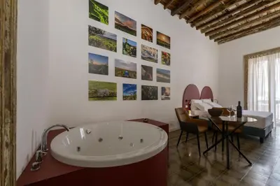 a bathroom with a tub and a table and a bed at Ballarooms Experience in Palermo